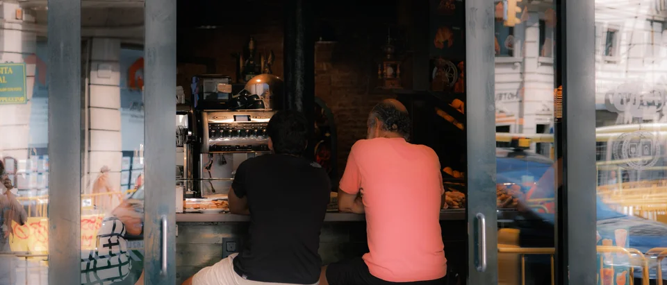 Two people at a café counter through the window