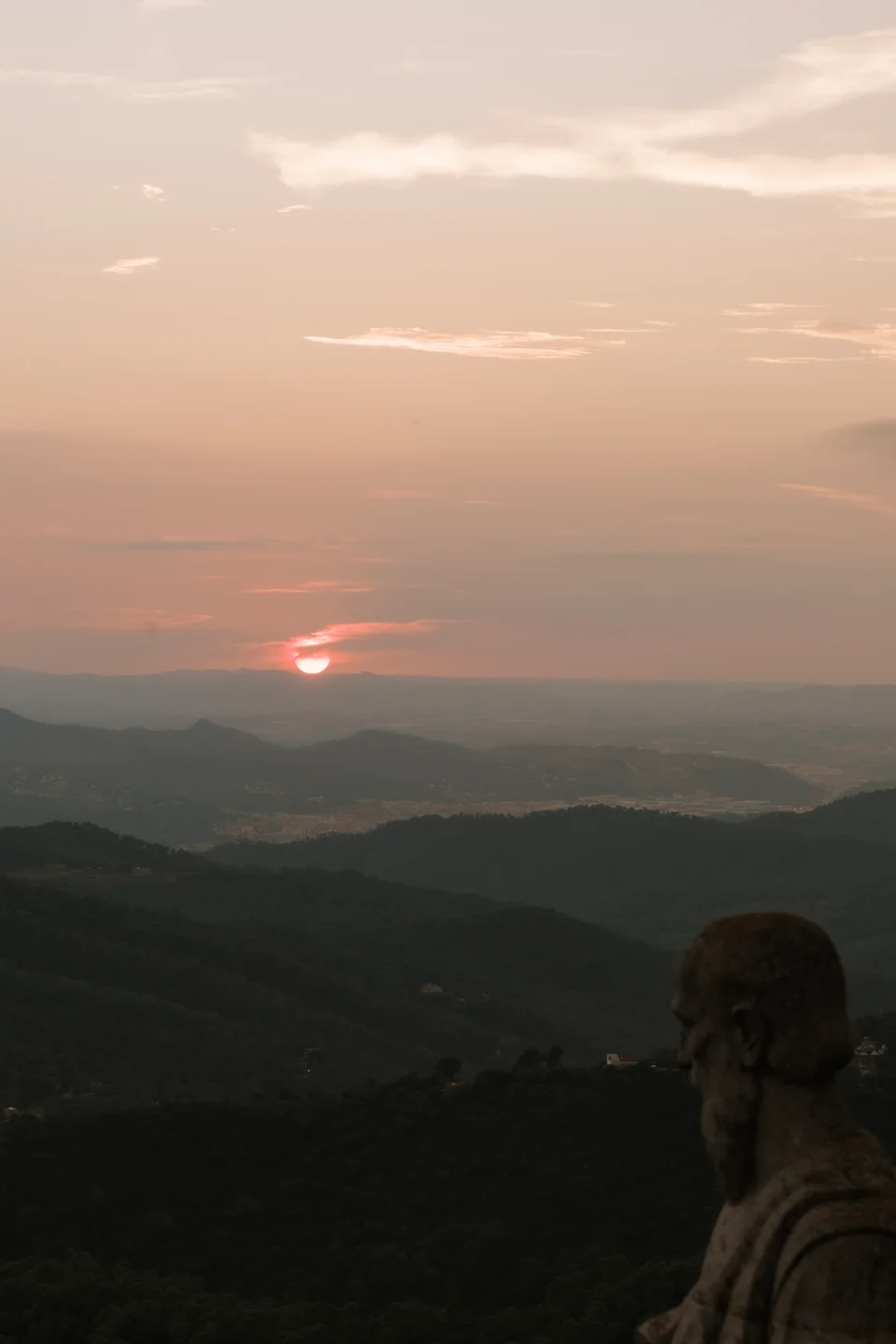 Stone figure in the foreground of a sunset