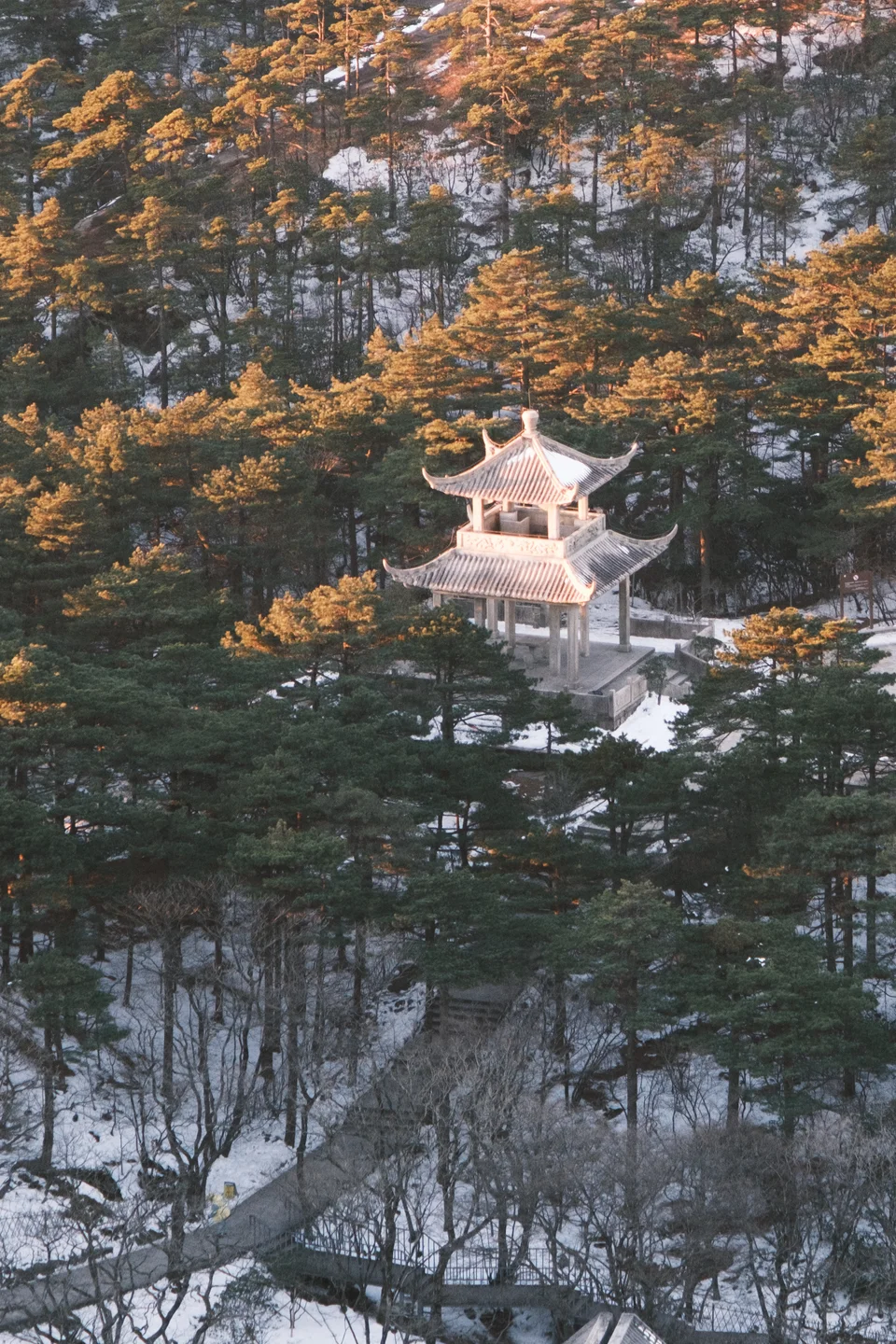 Pavilion surrounded by snowy forest and golden light